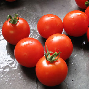 Red cherry tomatoes on a dark surface